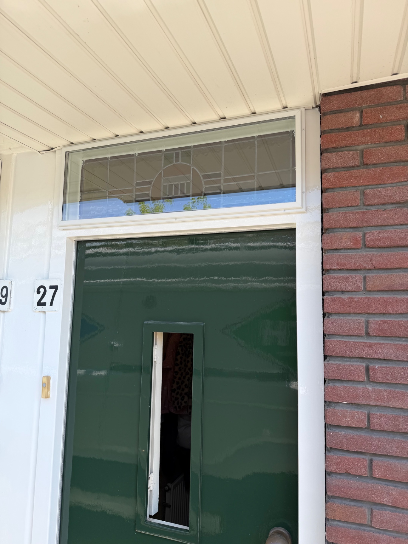 Voorzetraam boven een voordeur, op maat geplaatst